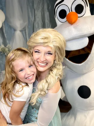 Elsa and Olaf sharing a big laugh with a delighted young girl at her party