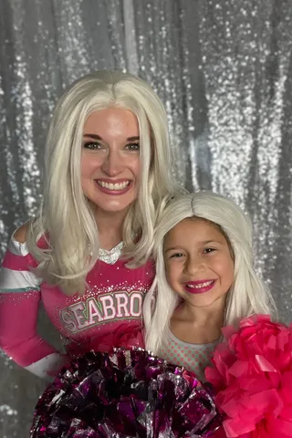 Addison smiling with a gap-toothed young girl against a sparkly backdrop