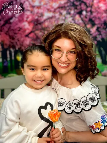 Mirabel smiling with a girl holding a small orange flower