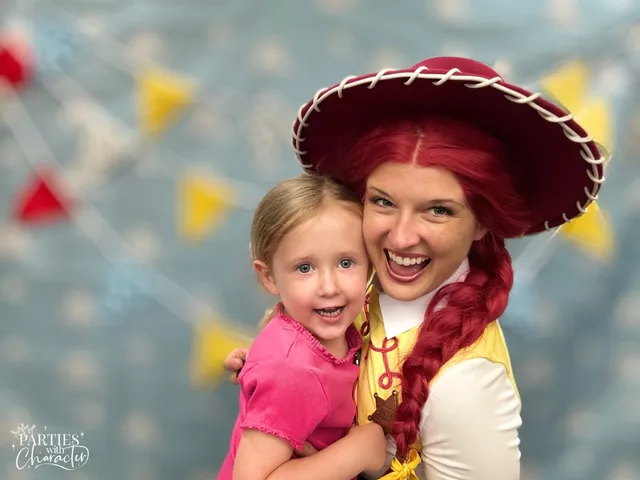 Jessie hugging a grinning young girl in a bright pink top