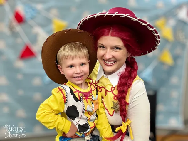 Jessie leaning in beside a young boy in a brown cowboy hat and Woody shirt