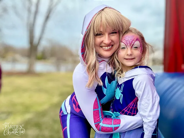 Ghost Spider hugging a young girl with pink face paint outdoors