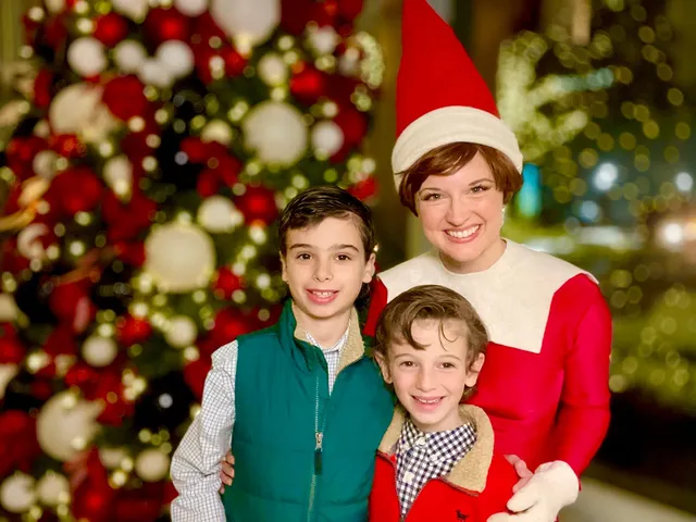 Elf on the Shelf posing with two young boys beside a large ornament-covered Christmas tree