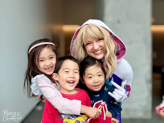 Ghost Spider group-hugging three children in a building lobby