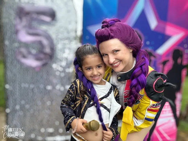 Rumi and a young girl in a black and gold sequin jacket smiling side by side