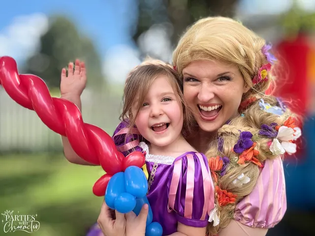 Rapunzel laughing with a girl waving a red twisted balloon sword
