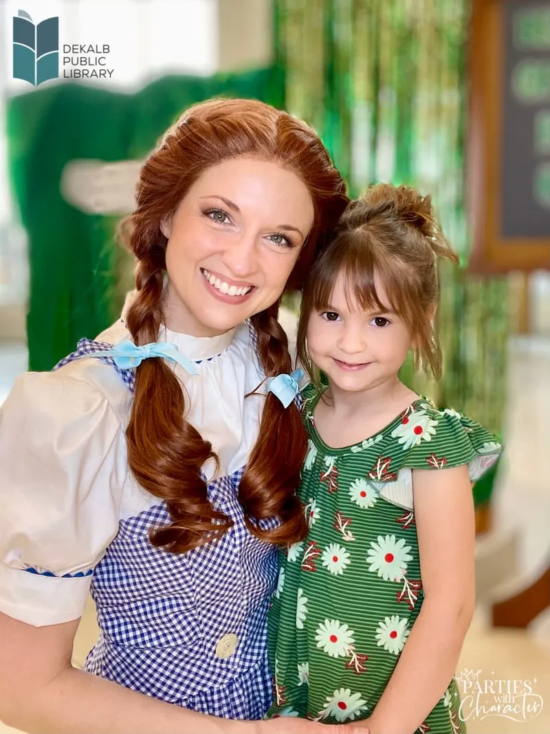 Dorothy hugging a young girl at a Wizard of Oz themed library party